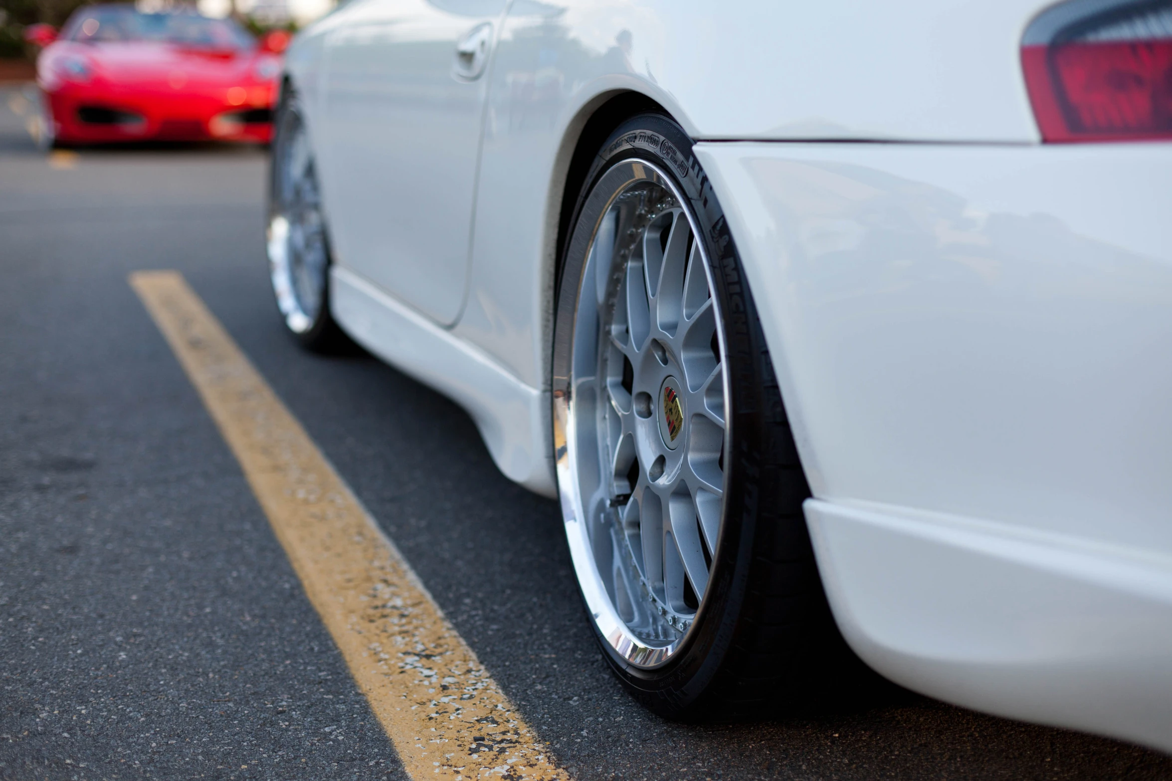 the back wheels of a white car on a street