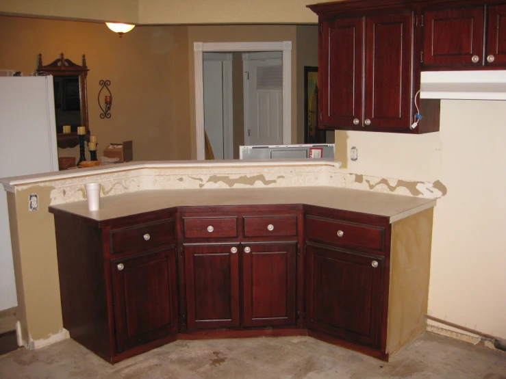 kitchen with wallpaper, cabinetry and flooring removed