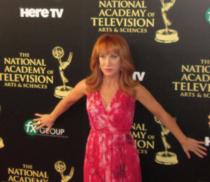 a woman in a dress is posing on a red carpet