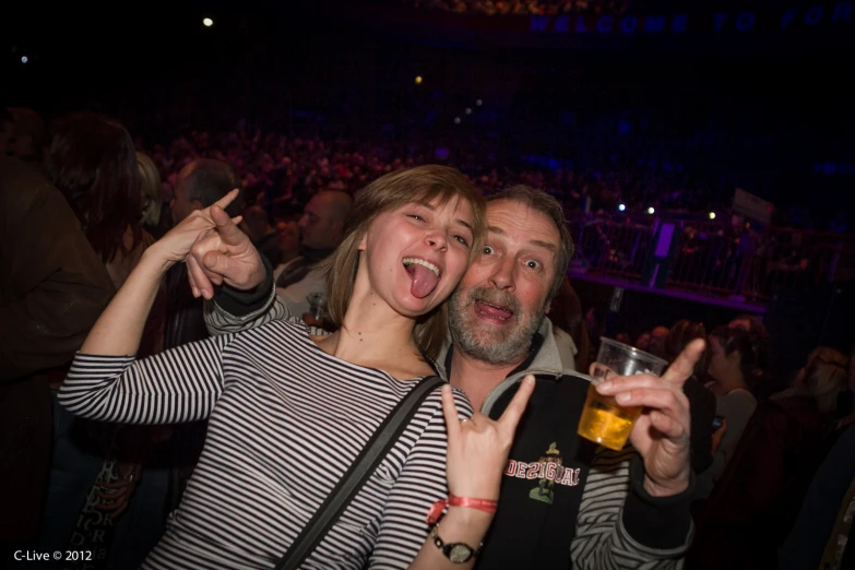 a man and woman pose for a po at a concert