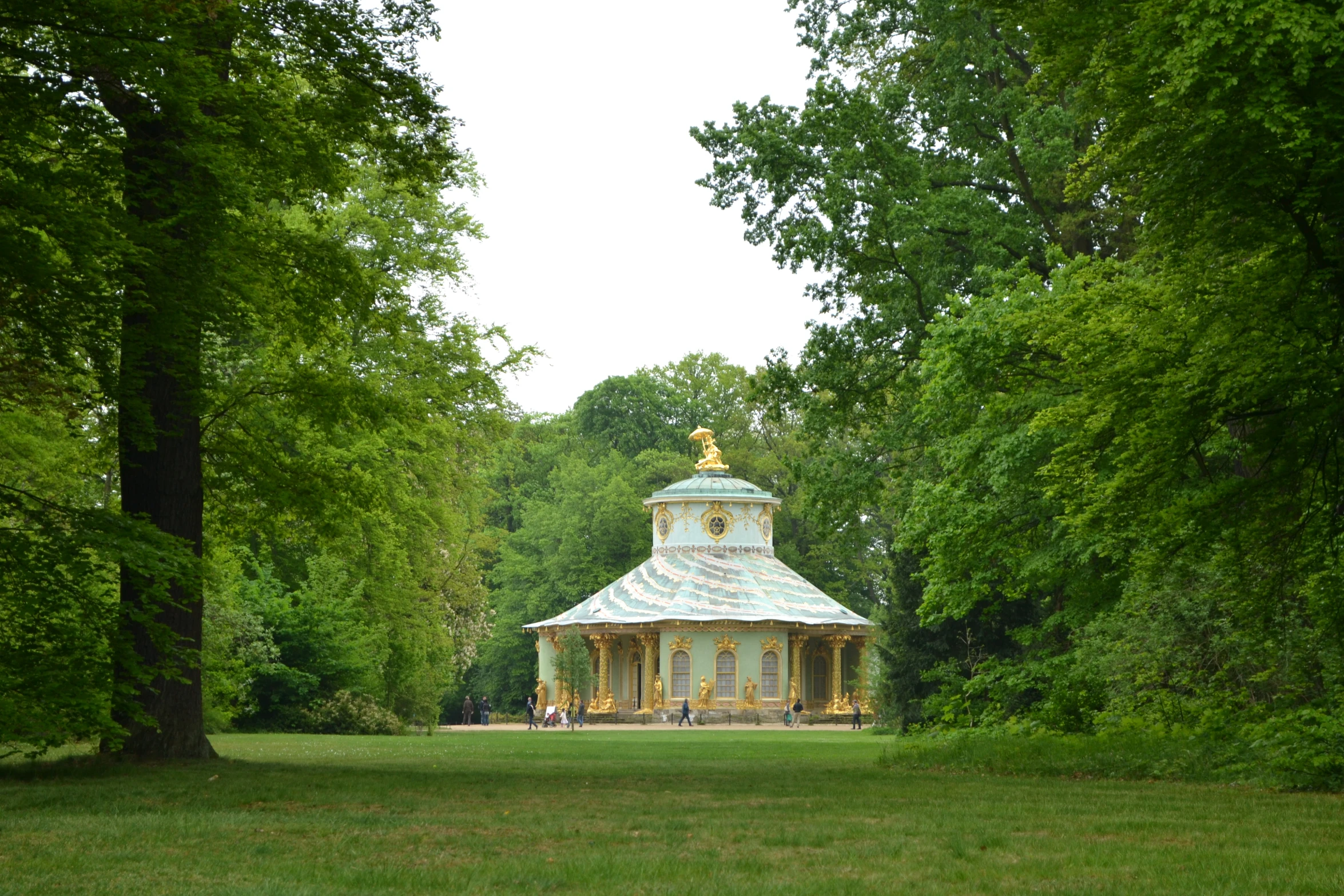 a pretty gazebo surrounded by green trees and grass