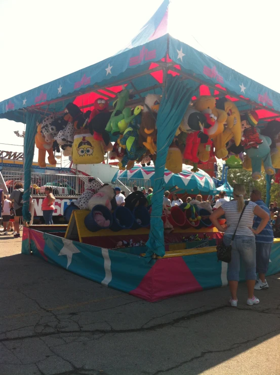 two people standing under a colorful tent at an amut park