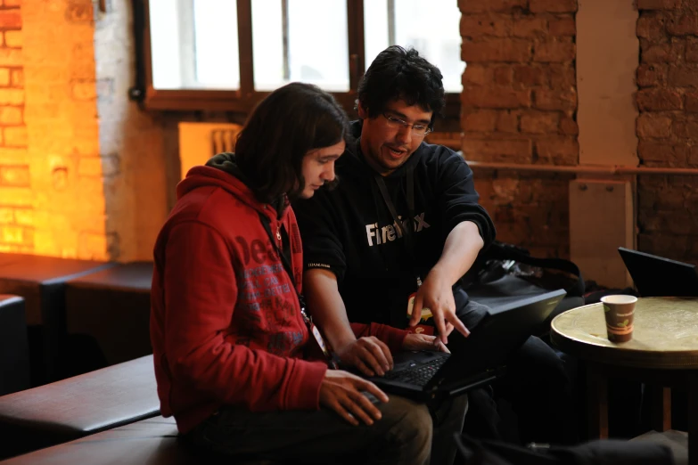 two people using their laptops on the counter