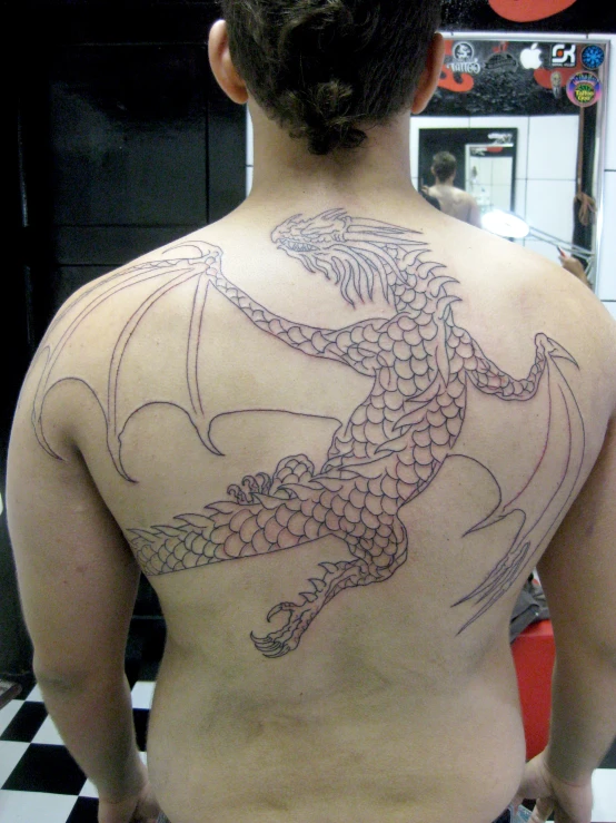 a woman with a dragon tattoo on her back