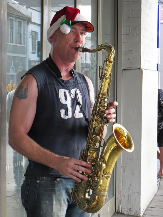 a man wearing a santa hat while playing a saxophone