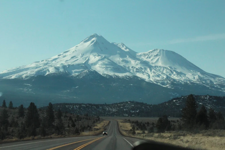 a car drives down the highway past a mountain