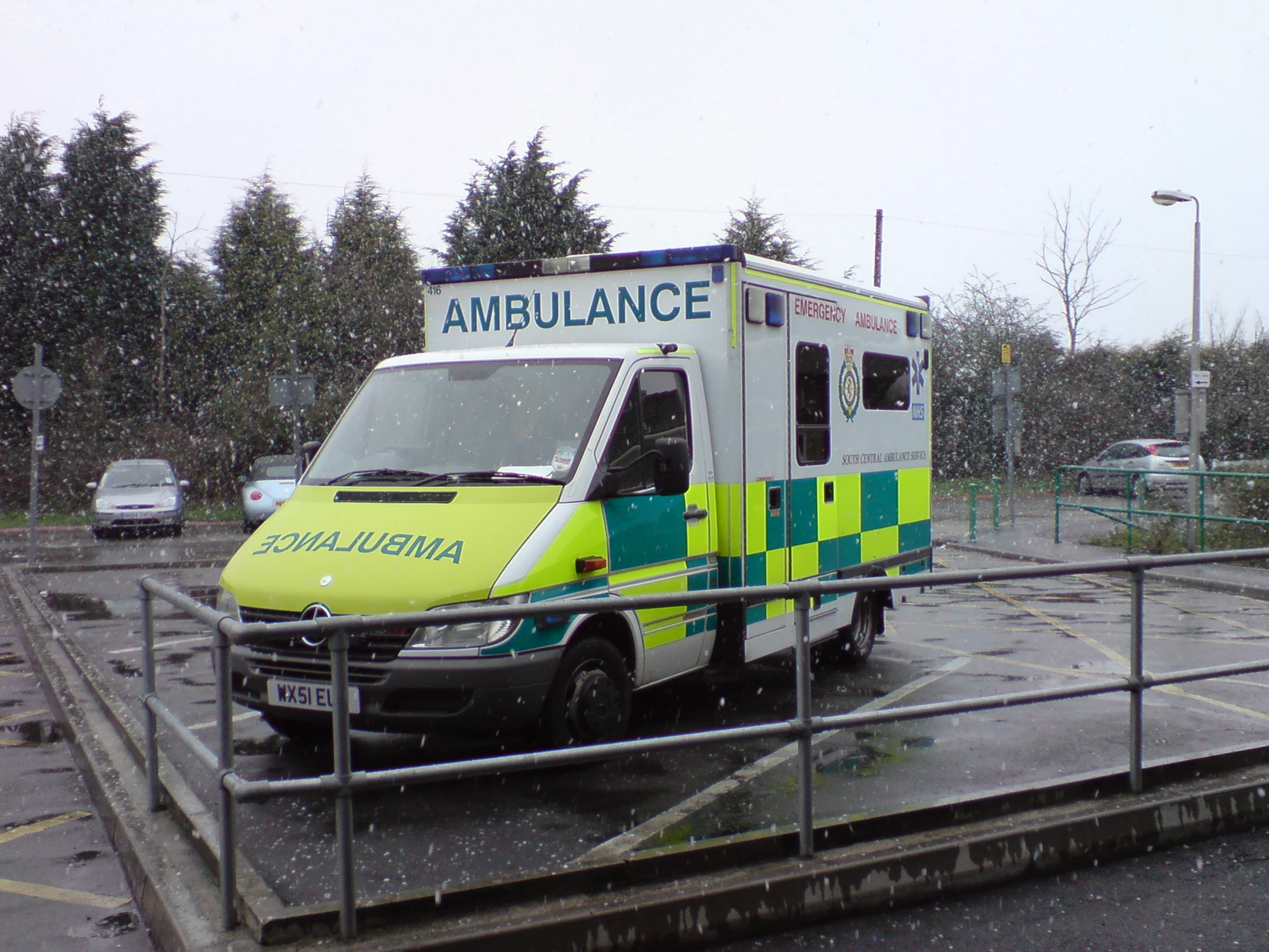 an ambulance parked at an ambulance station on a rainy day