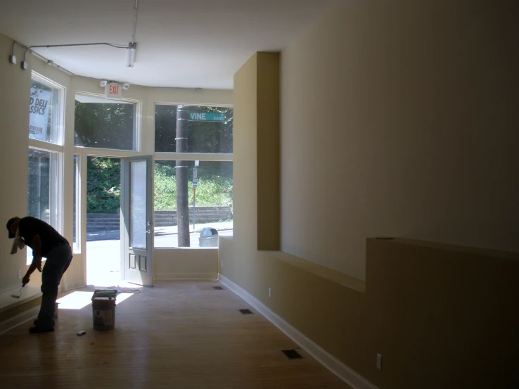 a woman is leaning over to paint a room