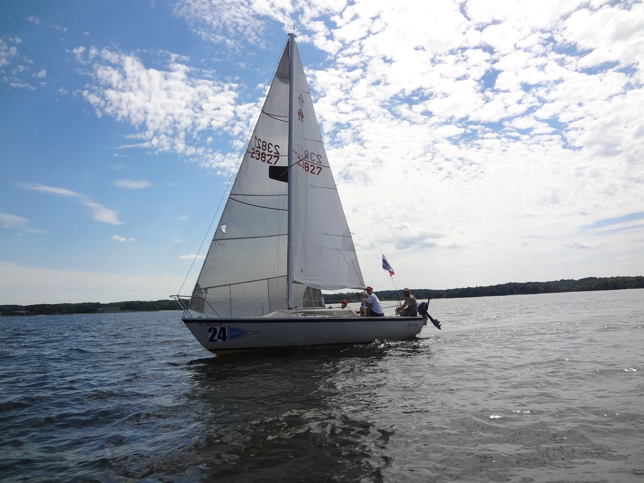 a small white sail boat is in the middle of the water