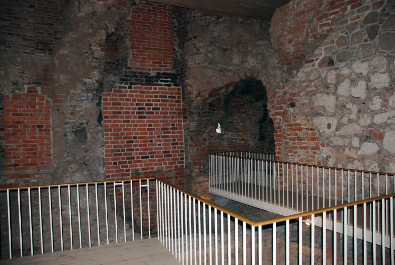 a stairwell in an abandoned building that is brick and white
