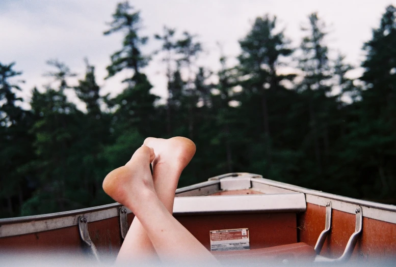 the bare feet of a person floating on a boat