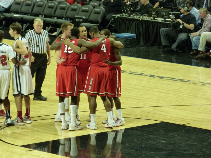 a group of young men standing on top of a basketball court