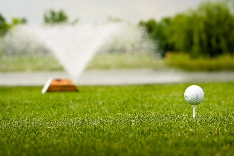 a golf ball and tee set with water shooting out