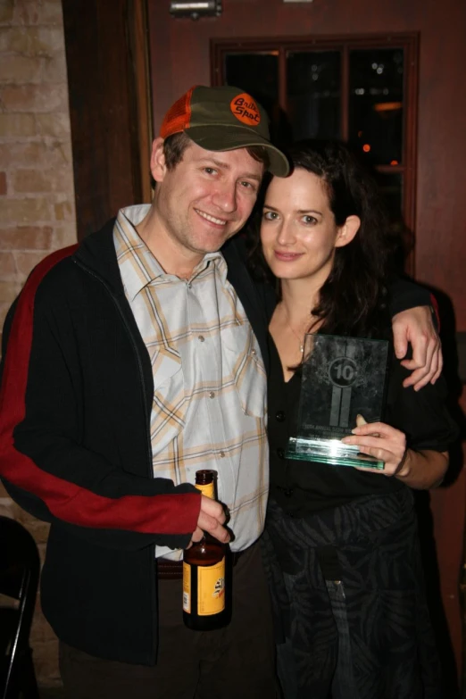 a man with a woman who has a beer in her mouth