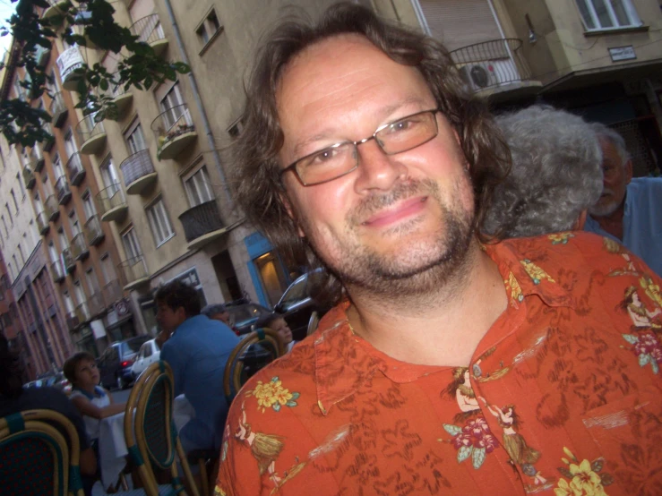 a man with glasses is standing in front of some tables