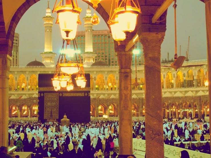 many people are gathered in a large, ornate courtyard