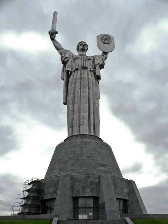 statue with large arms holding a light and two hats