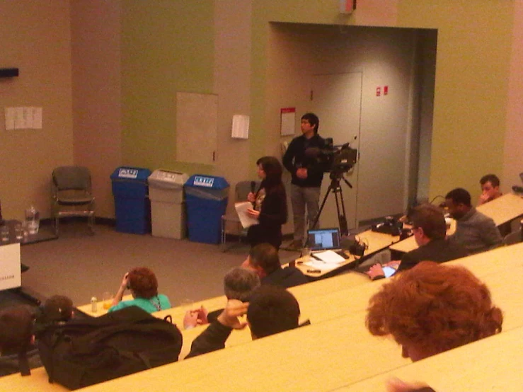 a man is in a classroom talking to a group of people