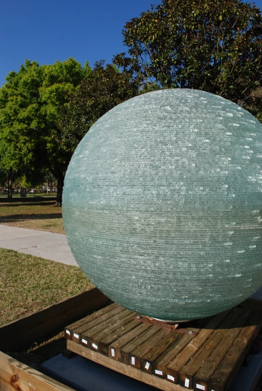 a large blue sphere sitting on top of a wooden pallet