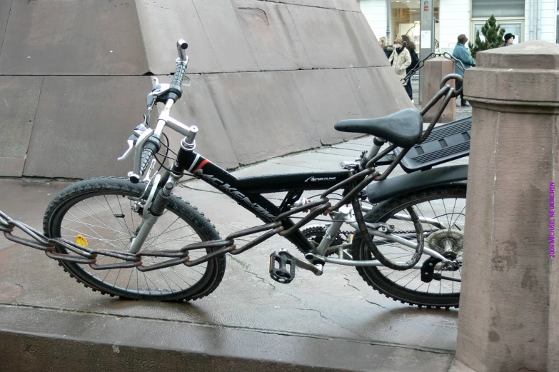 the bicycle is leaning against the concrete wall