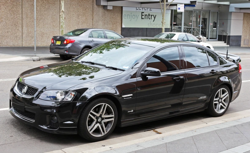 black car parked in front of a store next to the street