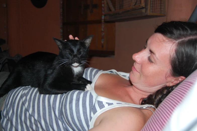 woman holding a cat on her lap in the bedroom