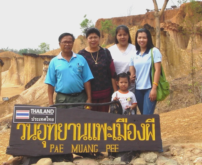 people stand beside a sign for a park