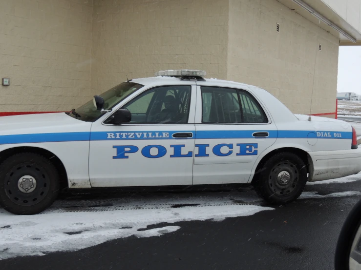 a white police car parked in front of a building