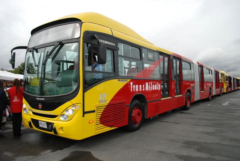 a line of buses that are parked in a parking lot