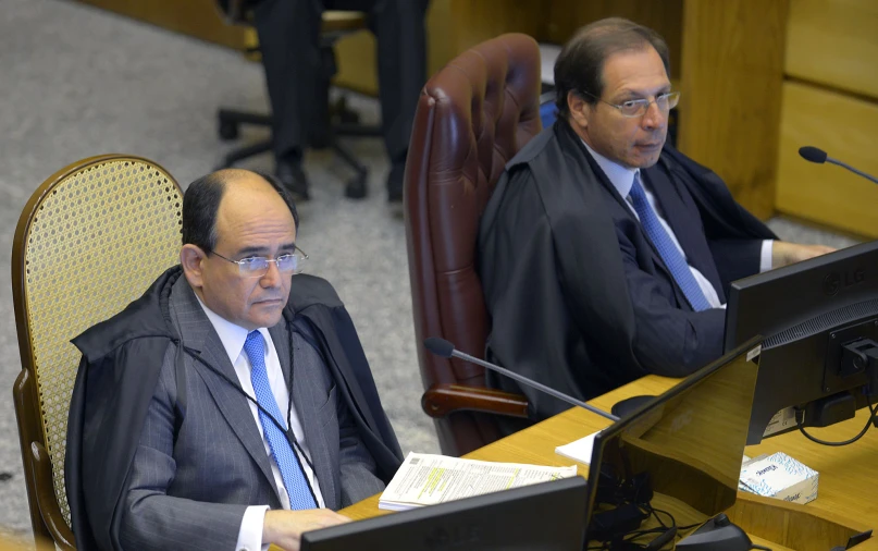 two men are in the assembly room working on computers