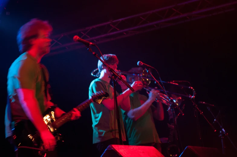 a band performing on stage with microphones in their hands