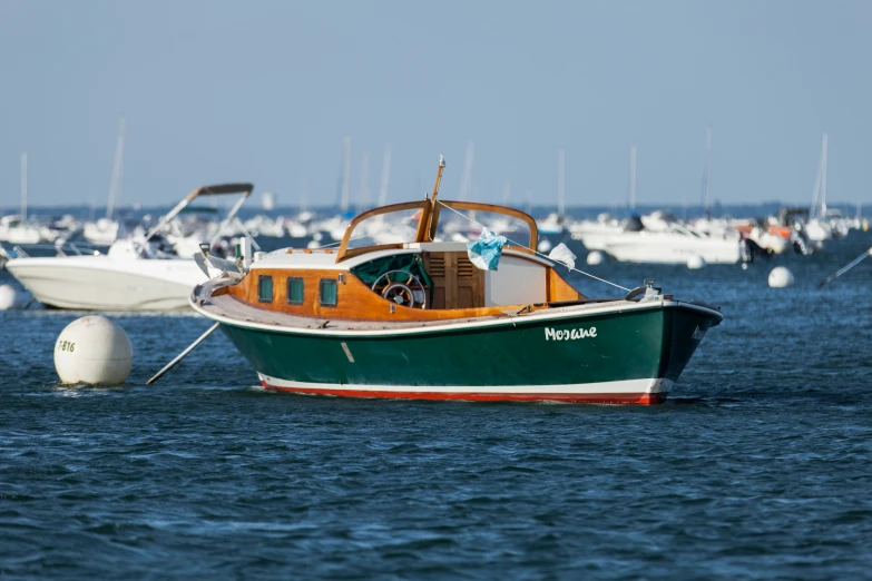 there is a boat in the water with other boats in the background