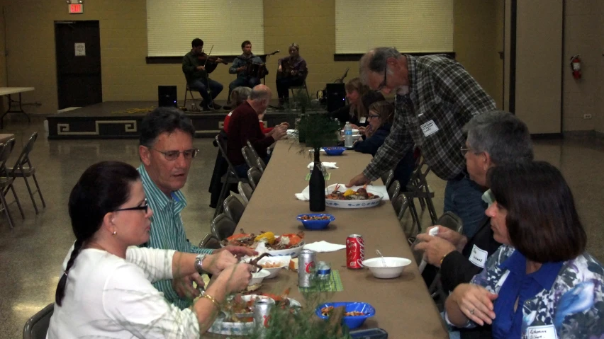 a group of people sitting at a long table eating