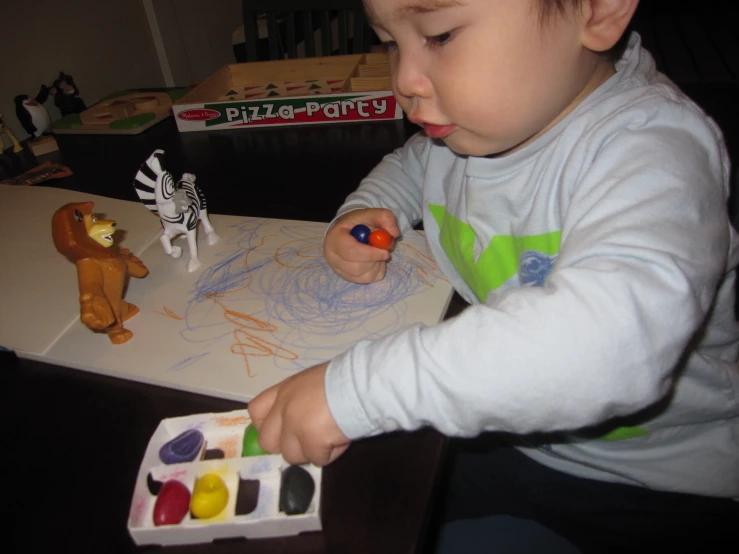 a baby playing with a set of animal toy figures