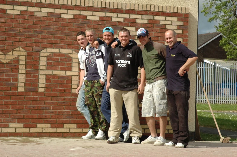 people stand in front of a brick building and pose for a picture