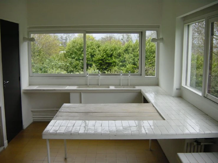 a large kitchen with an island table and an abundance of windows