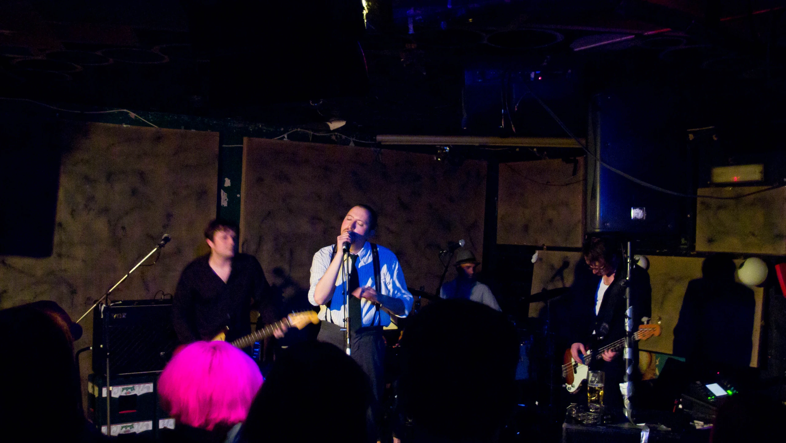 a group of men stand around a band on stage