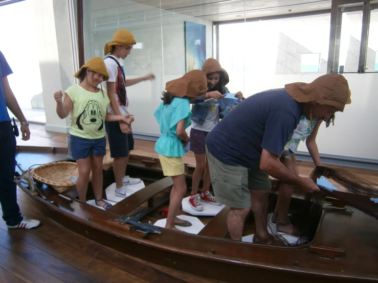 a group of people in hats and shoes standing on the edge of a boat