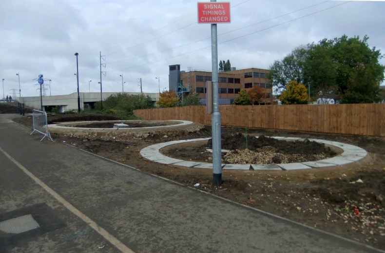 a pole next to a small garden area in a residential area