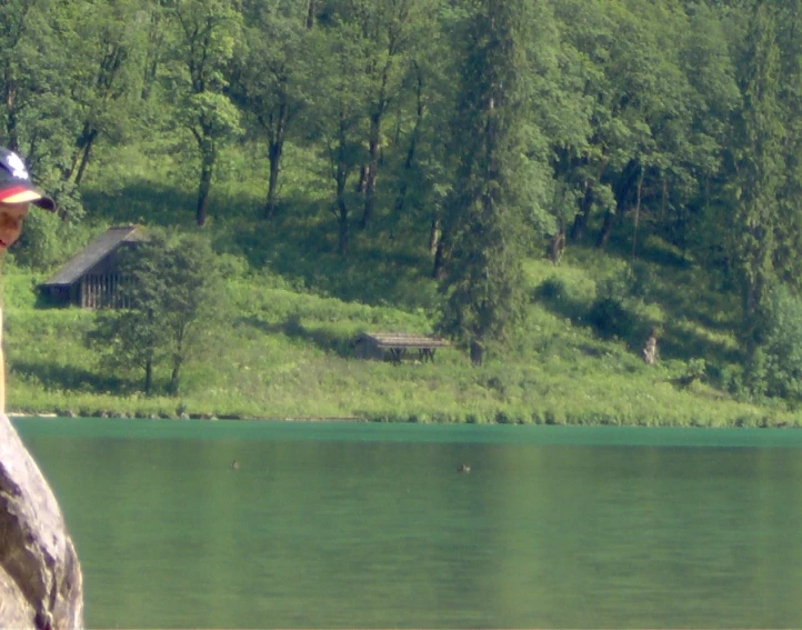 the person stands on top of a cliff beside a lake