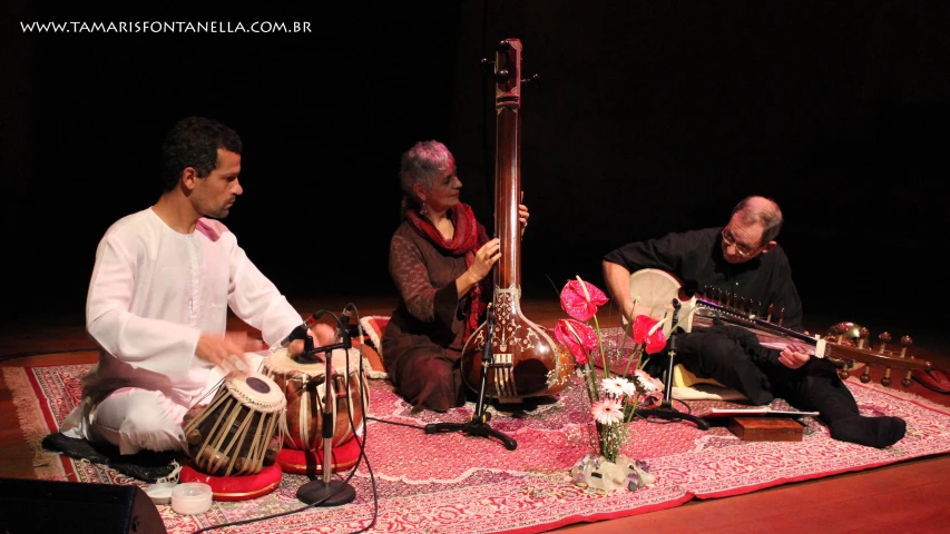 three men on stage playing music with other instruments