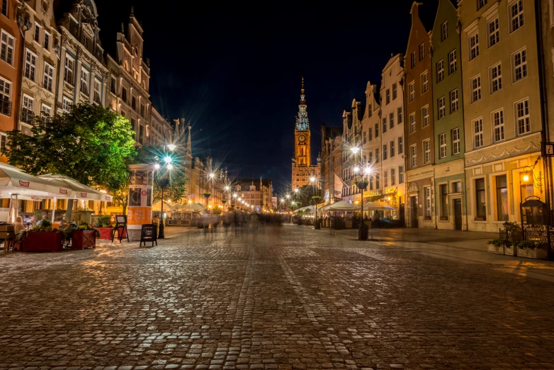 street scene of people walking down an empty street at night