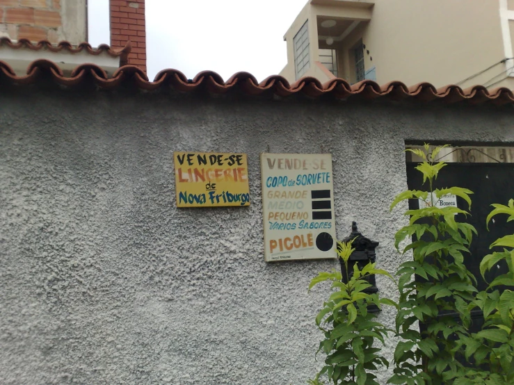 the exterior of a building with three signs on the side of it