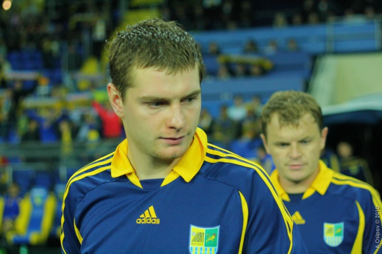 a young man holding a tennis racket in front of another young man