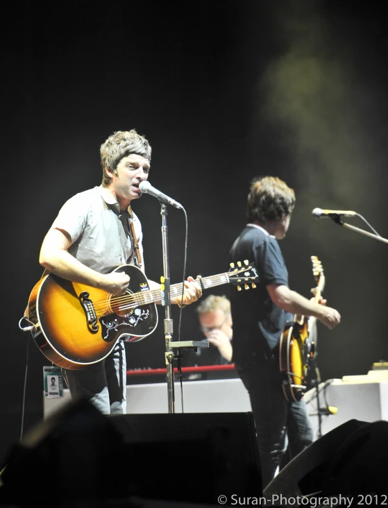 a man that is standing with a guitar