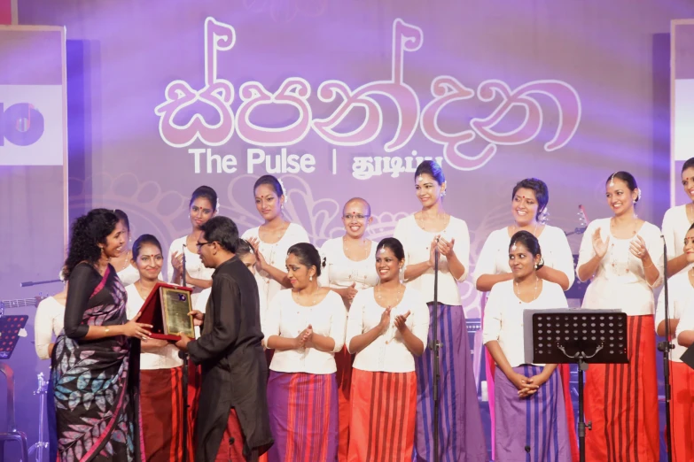 the women are posing for a picture while being awarded