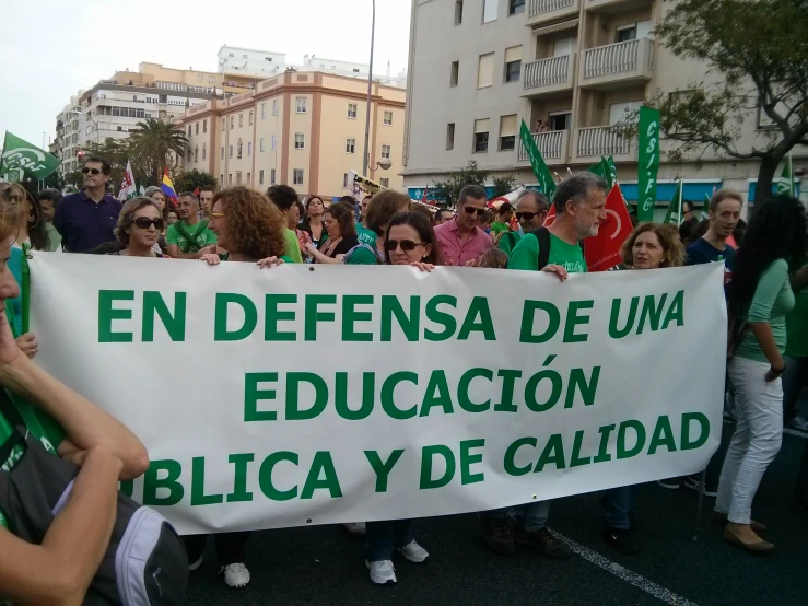 some people are holding up green banners and signs