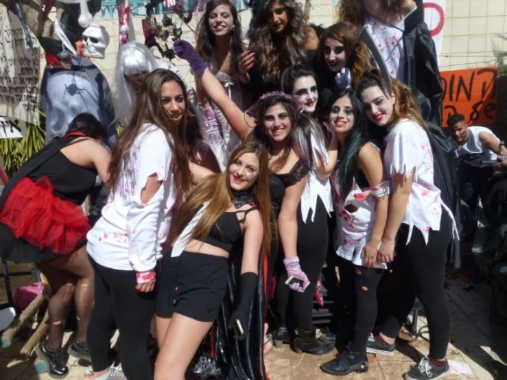several girls dressed up as witches and devil, posing for a po