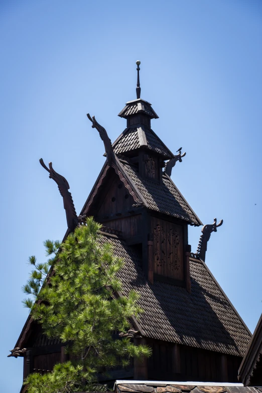 a wooden building with a tree in front of it