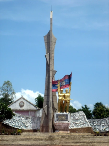 statue at base of tower with two flags